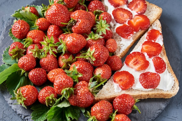 Sandwiches with fresh berries on dark background, top view