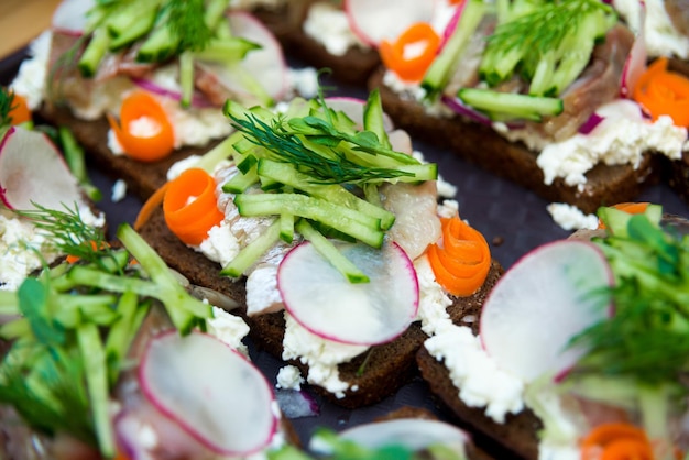 Sandwiches with herring radish cucumber and cream cheese on a dark rye bread