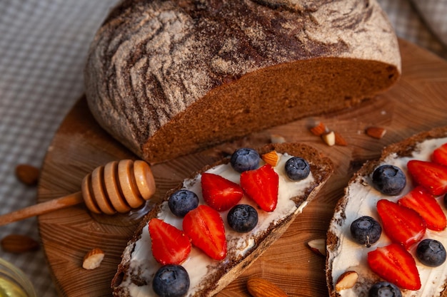 Sandwiches with homemade rye bread, honey, cheese and berries