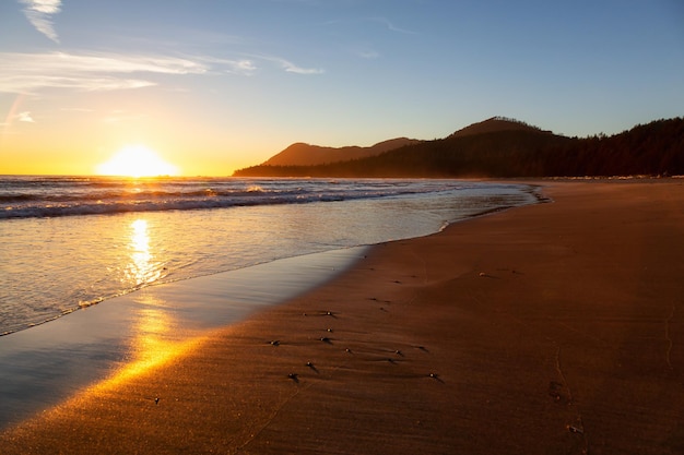 Sandy beach on the Pacific Ocean Coast during a vibrant summer sunset