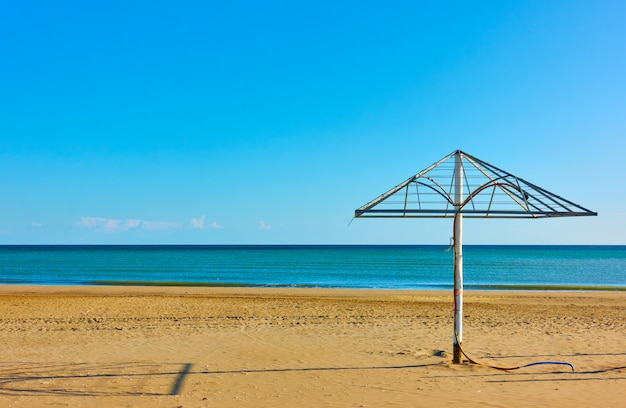 Sandy beach with old parasol in Rimini on the shore of the Adriatic sea, Italy