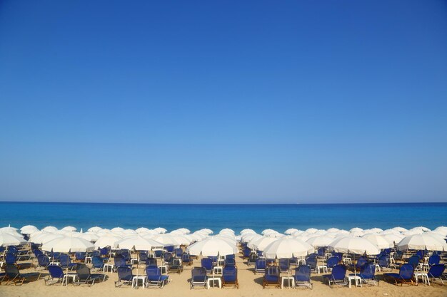 Sandy beach with white parasols and sunbeds Kathisma Lefkada