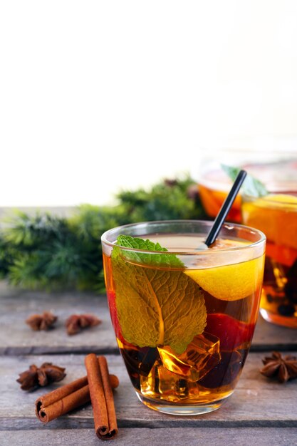 Sangria in bowl and glasses with Christmas decoration on wooden table close up