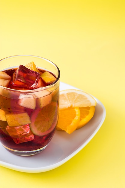 Sangria drink in glass isolated on yellow background