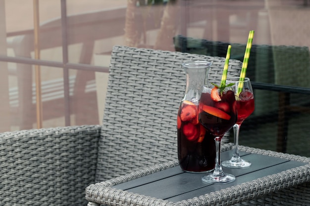 Sangria in jar and glasses with strawberries and oranges. Place For Text