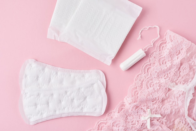 Photo sanitary pad, menstrual cup, tampon and panties on a pink background