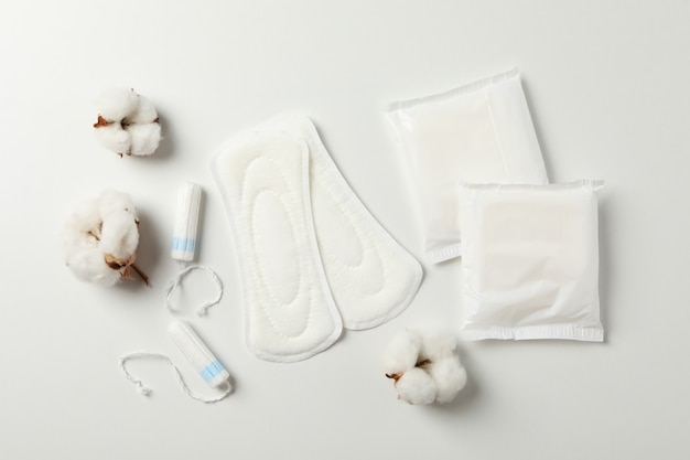 Photo sanitary pads, tampons and cotton on white surface