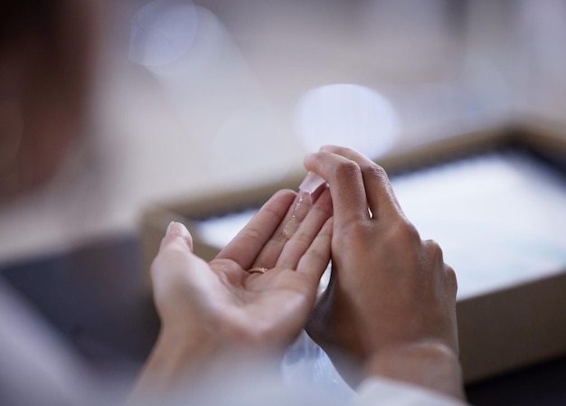 Sanitise your hands before anything else Shot of an unrecognizable businessperson sanitising their hands at work