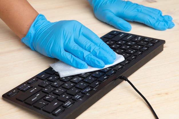 Photo sanitizing office space wiping corona virus cleaning and disinfection of your workspace.