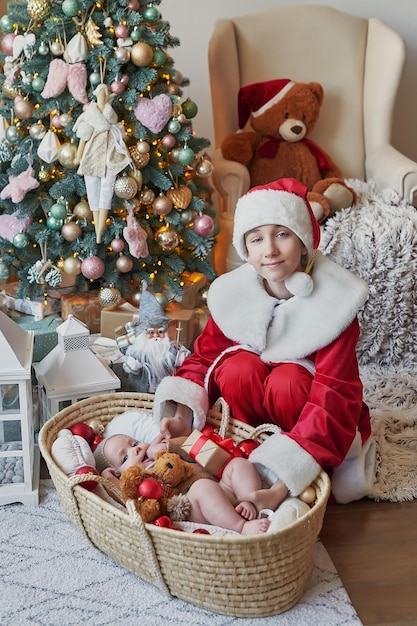 Santa Claus and baby on background of Christmas tree Happy new year and merry christmas Christmas family