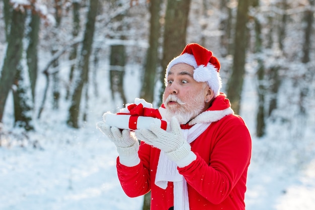 Santa Claus blows snow off of gift