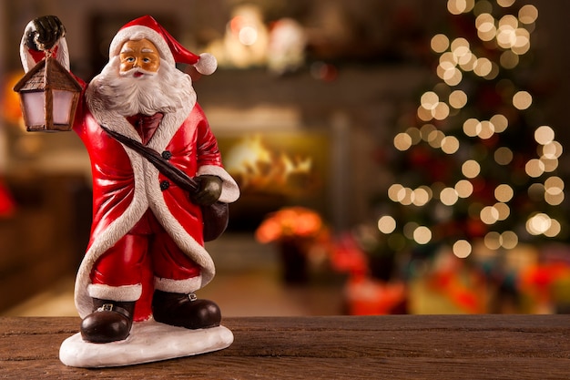 Santa Claus decoration on the table on a christmas blurry background.