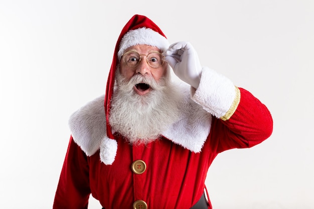 Santa Claus in eyeglasses is looking surprised at camera on white background