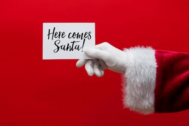 Santa Claus hand holding a Christmas sign