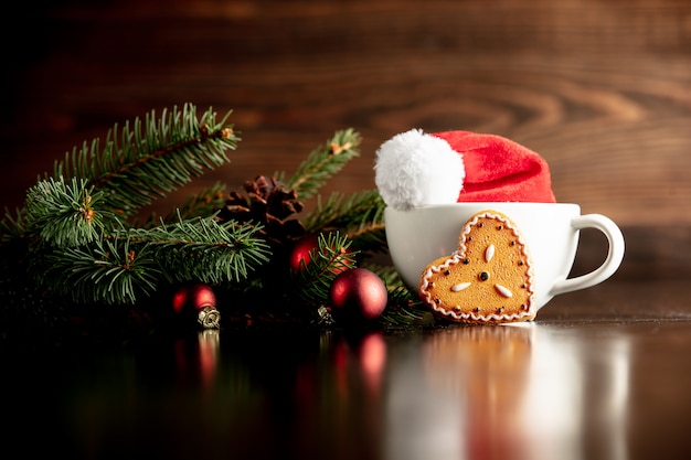 Santa Claus hat and cup with gingerbread cookie