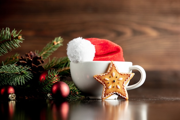 Santa Claus hat and cup with gingerbread cookie