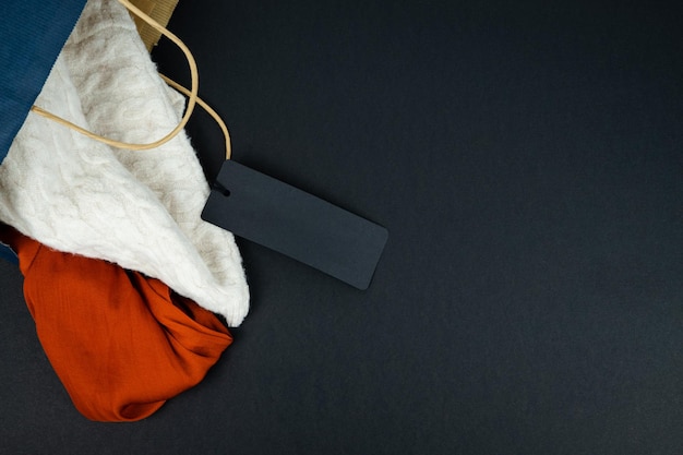 Santa Claus hat and paper bag with label without text on black background Copy space