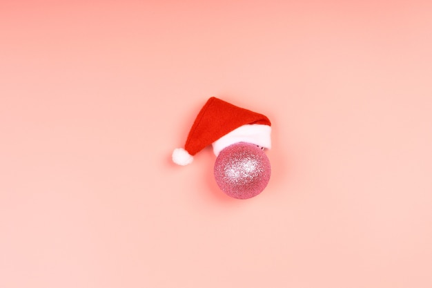 Santa Claus hat on a pink background. minimalistic christmas scandy background with empty place for text