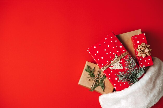 Santa claus hat with gift boxes on red background christmas presents and santa hat on red background