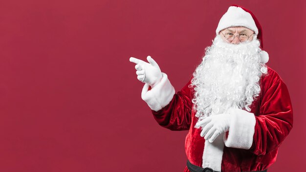 Photo santa claus in hat with pointing hand