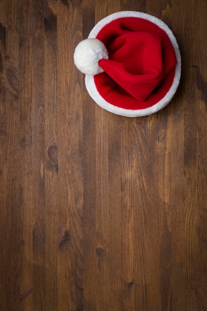 Santa Claus hat on a wooden background with flying snowflakes Christmas New Year