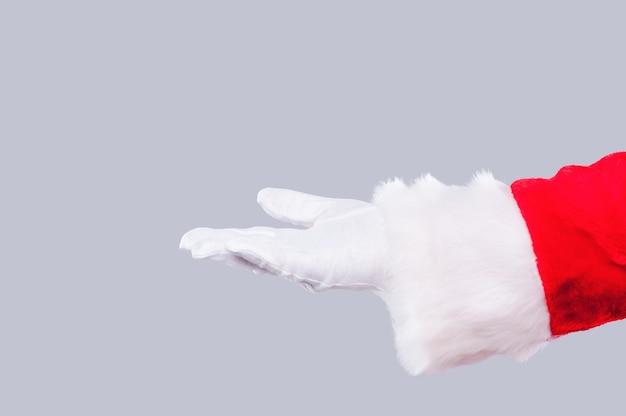 Santa Claus holding copy space. Close-up of Santa Claus holding copy space against grey background