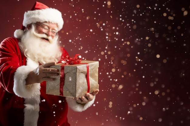 a santa claus holding a gift with a red background