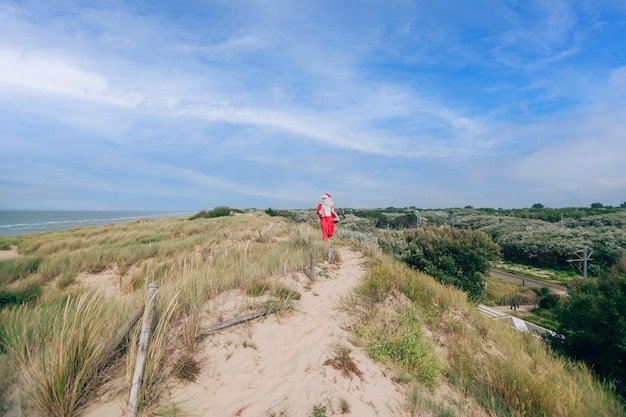 Santa Claus on holiday by the sea with walking on the dunes