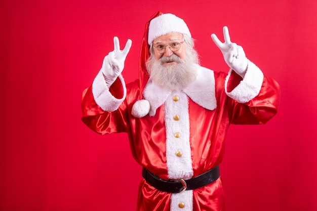 Santa Claus looking at the camera. Christmas is coming. Merry Christmas. Peace. V sign.