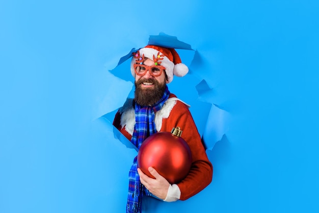 Santa claus man holds big christmas ball winter holidays new year discount sale christmas sales