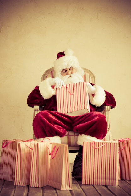 Photo santa claus senior man against grunge background. christmas shopping concept