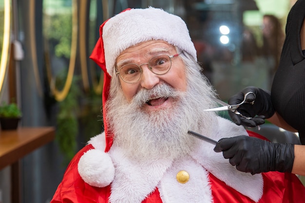 Santa Claus shaving in barbershop. Getting ready for Christmas. Beautifying for the holidays. Bearded. Cuting.