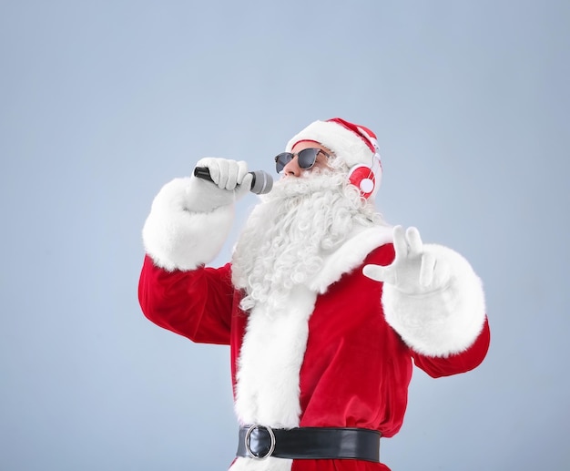 Santa Claus singing Christmas songs on light background