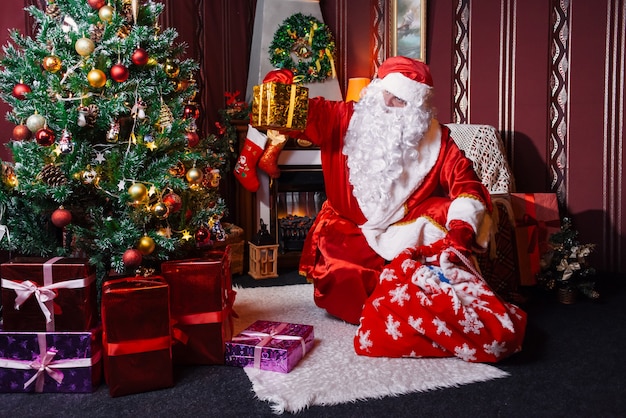 Santa Claus sitting next to a Christmas tree