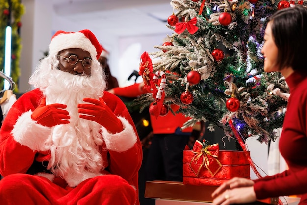 Santa Claus sitting next to xmas tree