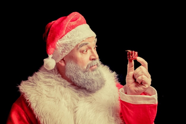 Santa Claus surprised looking at a very small gift