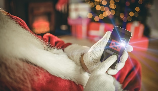 Santa claus touching a smartphone at christmas at home in the living room