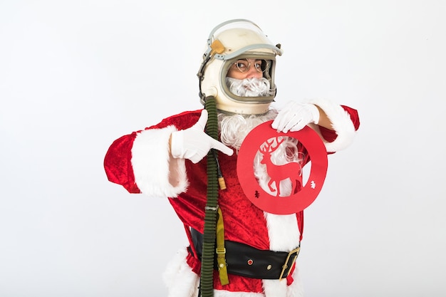 Santa Claus with astronaut helmet holding a with a reindeer traffic sign on white background