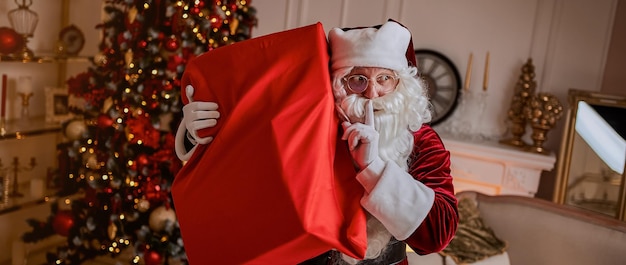 Santa claus with big bag full of gifts children new year and merry christmas advertising banner