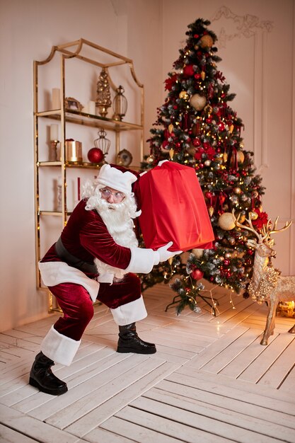 Santa Claus with a big red bag of gifts rush to bring present to children. New year and Merry Christmas , happy holidays concept