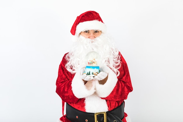 Santa Claus with a christmas snow globe in her hands, on white background