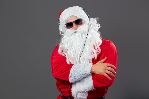 Santa Claus with a long white beard and in sunglasses and headphones