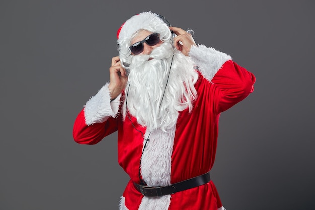 Santa Claus with a long white beard and in sunglasses and headphones