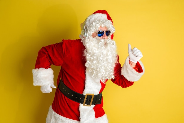 Santa claus with modern eyeglasses isolated on yellow studio background