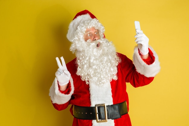 Santa claus with modern eyeglasses isolated on yellow studio background