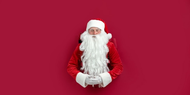 Santa Clause peeks through a paper hole and waits christmas sale christmas advertisement concept