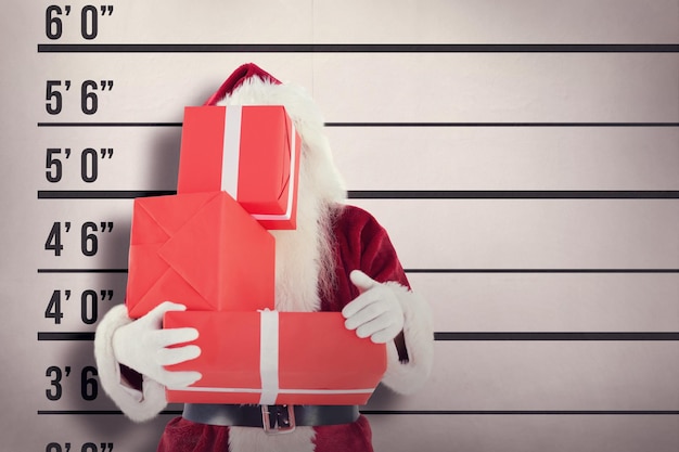 Photo santa covers his face with presents against mug shot background