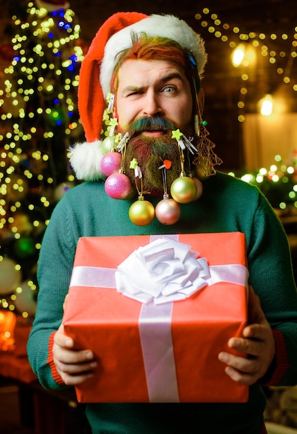 Santa man with decorated beard for new year bearded male with christmas gift new year present box