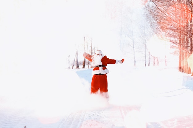 Santa in the winter field. Santa magical fog walking along the field. Santa on Christmas Eve is carrying presents to children in a red bag