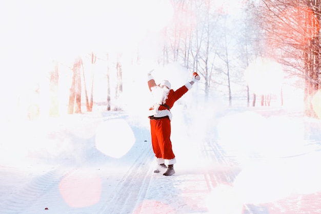 Santa in the winter field. Santa magical fog walking along the field. Santa on Christmas Eve is carrying presents to children in a red bag